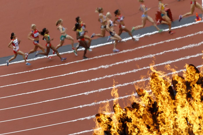 Các VĐV thi đấu nội dung 5000m của nữ đang chạy qua ngọn đuốc Olympic 2012.